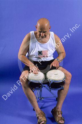 A man plays bongo drums.