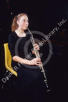 A girl plays an english horn.