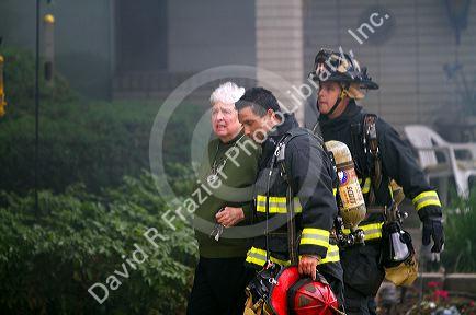 Firefighters assist a resident during a house fire in Boise, Idaho, USA.