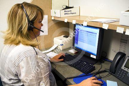 Election worker uses a computer to verify absentee ballot signatures with voter registration card signatures in Boise, Idaho, USA.