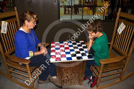 Grandmother and grandson play a game of checkers at a Cracker Barrel in Brandon, Florida, USA.