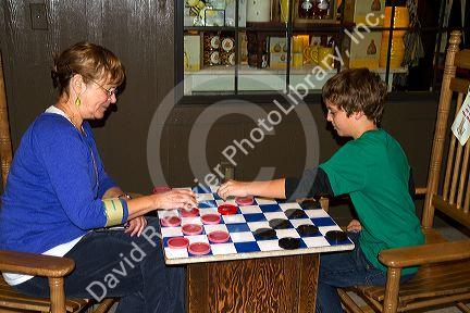 Grandmother and grandson play a game of checkers at a Cracker Barrel in Brandon, Florida, USA.