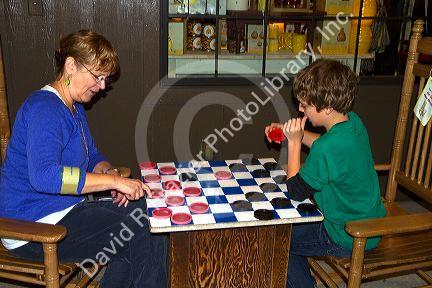 Grandmother and grandson play a game of checkers at a Cracker Barrel in Brandon, Florida, USA.