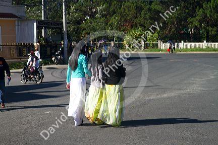 Vietnamese students walking in traditional dress in Da Lat, Vietnam.