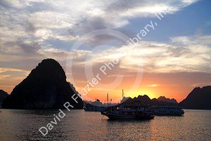 Tour boats at sunset in Ha Long Bay, Vietnam.