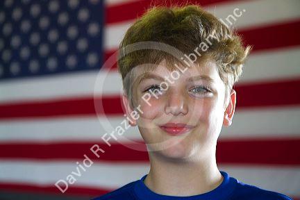 Ten year old american boy standing in front of an american flag in Charleston, South Carolina, USA. MR