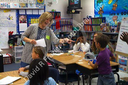Teacher in fourth grade classroom with students, USA.