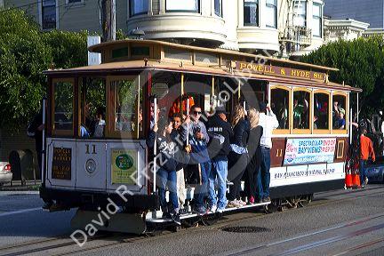 Passengers ride a cable car in San Francisco, California, USA.