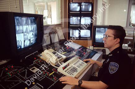 A police officer working in the control room of a jail.