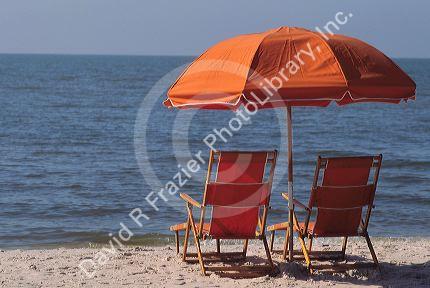 Gulf coast beach scene with chair and umbrella.