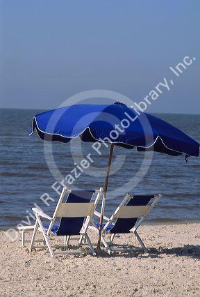 Gulf coast beach scene with chair and umbrella.