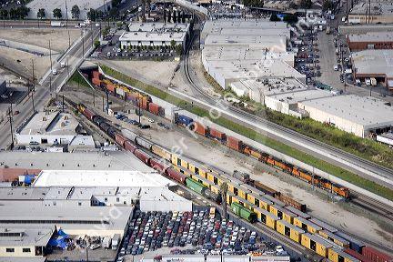 Aerial view of a train coming out of the Long Beach Corridor, Los Angeles, California.  Giant ditch allows trains to pass below grade level and avoid any crossing conflicts with autos.