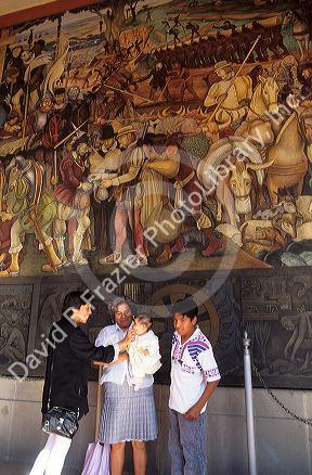 Visitors  view the Diego Rivera mural at the National Palace in Mexico City, Mexico.