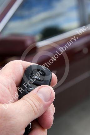 Person using a remote system to lock and unlock car doors.