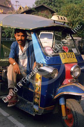 A man sitting in his tuk-tuk, Bangkok, Thailand.