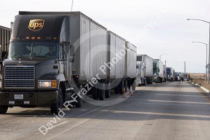 Long haul trucks line up a weigh station.
