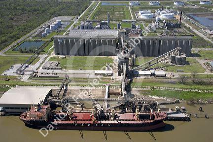Grain elevators and river barge being loaded along the Mississippi River near New Orleans, Louisiana.