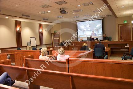 Video arraignment in criminal court in Boise, Idaho.  Defendants appear on video screen from secure jail facility while judge in courtroom conducts arraignment and sets bond.