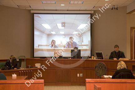 Video arraignment in criminal court in Boise, Idaho.  Defendants appear on video screen from secure jail facility while judge in courtroom conducts arraignment and sets bond.