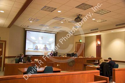 Video arraignment in criminal court in Boise, Idaho.  Defendants appear on video screen from secure jail facility while judge in courtroom conducts arraignment and sets bond.