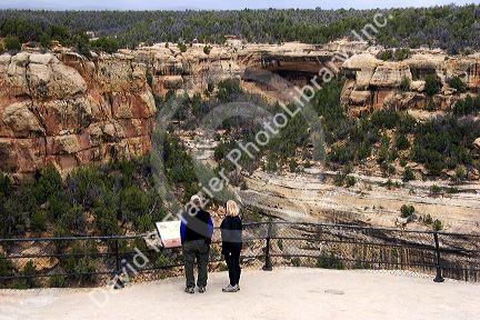Visitors read a sign at the cliff dwellings in Mesa Verde, Colorado.