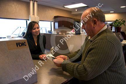 Customer depositing cash at a teller window.