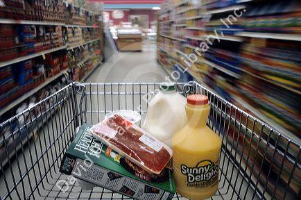 Groceries in a shopping cart moving down the isle in a supermarket.  Power shopping.