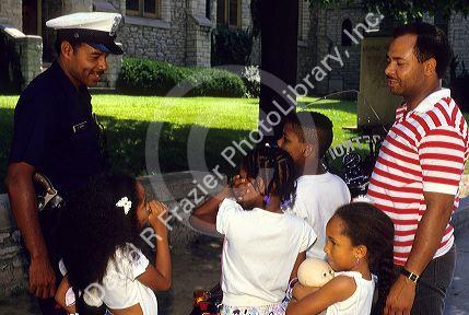 African american policeman talking with children.