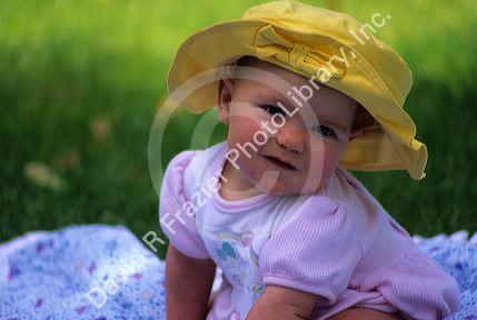Baby girl wearing a sunhat.