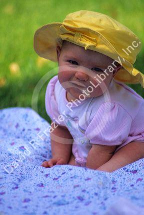 Baby girl wearing a sunhat.
