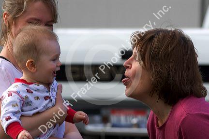 Woman sticking her tongue out at a baby to make it laugh.