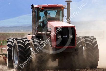 Four wheel drive tractor with dual tires planting wheat in Camas County, Idaho.