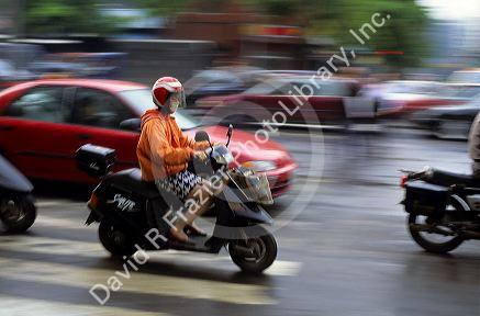 A woman wears a face mask to filter pollution while riding a scooter in Taipei, Taiwan.