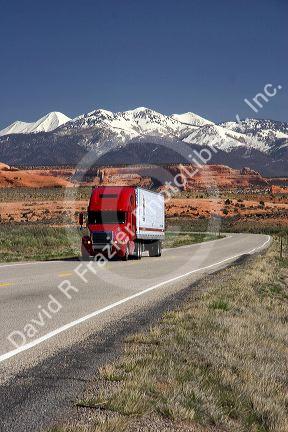Semi truck traveling on US highway 191 south of Moab, Utah.  La Sal Mountains in background.