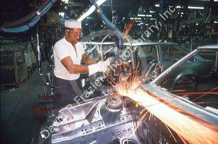 African American male works at Ford assembly line in Detroit, Michigan welding auto body.