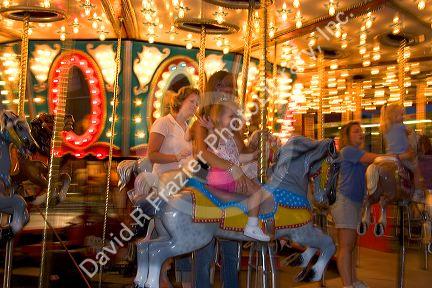 Children and adults ride a carousel at the Iowa state fair in Des Moines.