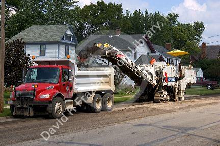 A road construction crew uses machinery to recycle asphalt in Oceola, Iowa.