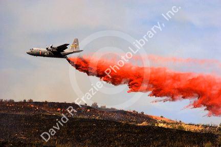 A  C-130 Hercules  airplane drops fire retardant on a fire in the Boise foothills, Idaho.