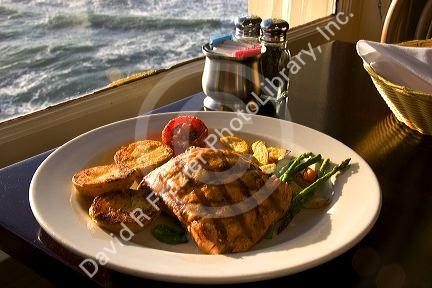 A dinner of salmon and ocean view at The Cliff House Restaurant on the San Francisco Coast, California.
