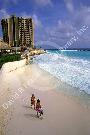 A couple walks on the beach in Cancun, Mexico.