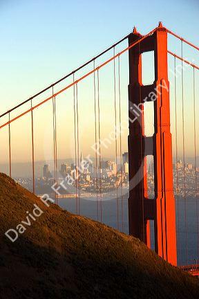 The Golden Gate Bridge and bay at San Francisco, California. Transamerica Pyramid tower is seen through suspension cables of north tower.