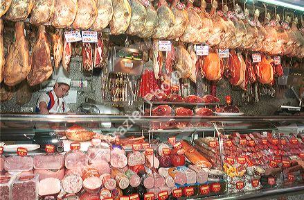 Hams hang in butcher shop in Madrid Spain.  