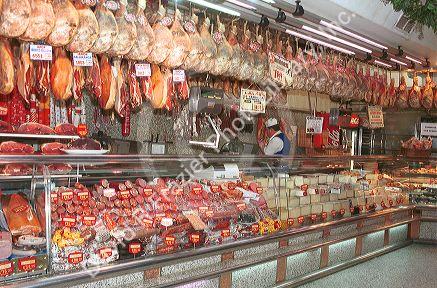 Hams hang in butcher shop in Madrid Spain.  