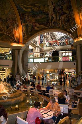 Fresco paintings adorn the ceiling of Galeria Pacifico and cafe seating in Buenos Aires, Argentina.