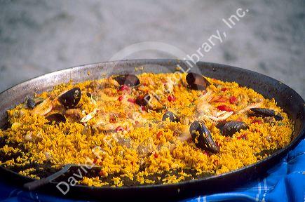 Paella with fresh seafood is displayed in a traditional paella dish in Spain.