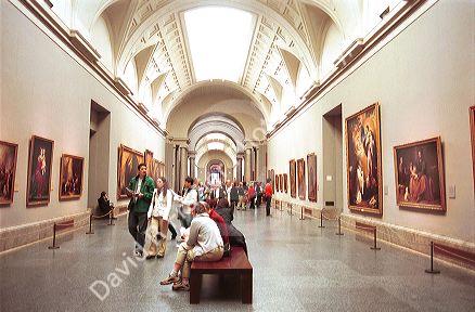 Interior of the Prado art museum showing paintings and vistors in Madrid, Spain.