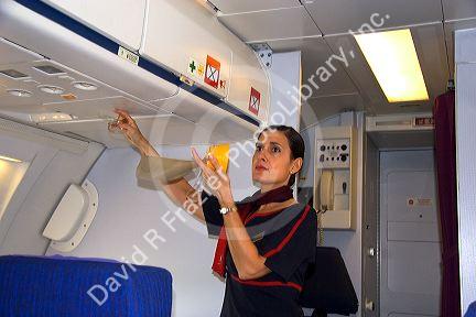 Flight attendant showing how to use an oxygen mask in case of emergency.