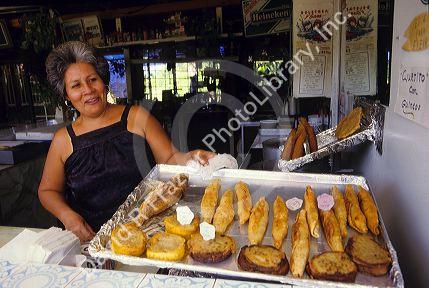 A woman sells fried Puerto Rican food at a sidewalk cafe in Puerto Rico.