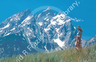 Woman walking in front of the Teton Mountains in Wyoming.