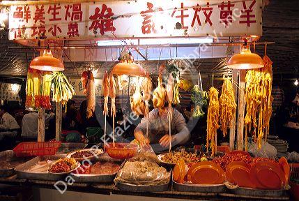 A man works at a night market selling meat and fish in Hong Kong.